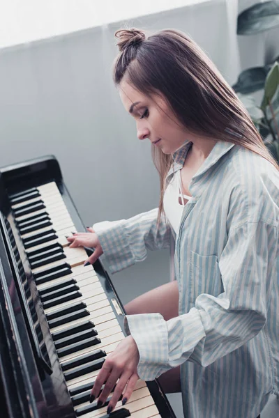 Attraente musicista suonare il pianoforte in soggiorno — Foto stock