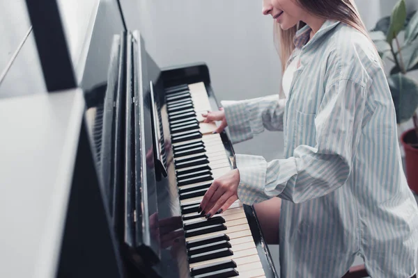 Ausgeschnittene Ansicht eines Musikers, der Klavier spielt und im Wohnzimmer lächelt — Stockfoto