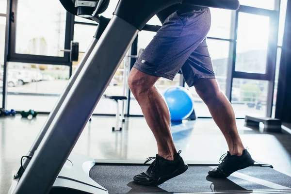 Ausgeschnittenes Bild eines Sportlers, der im Fitnessstudio auf dem Laufband läuft — Stockfoto