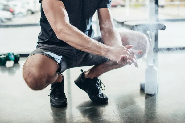 Abgeschnittenes Bild eines Sportlers, der vor dem Training im Fitnessstudio Talkumpuder auf die Hände aufträgt — Stockfoto