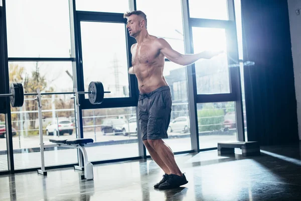 Schöner hemdloser Sportler beim Training mit Springseil im Fitnessstudio — Stockfoto