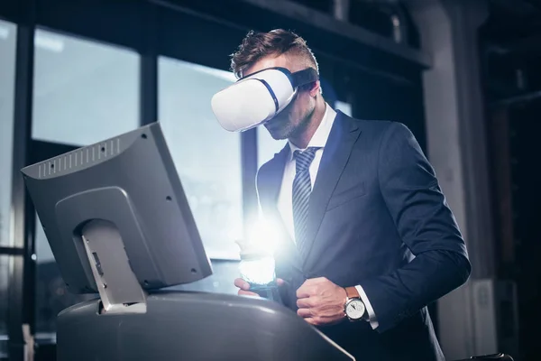 Tiefansicht des Geschäftsmannes im Anzug und Virtual-Reality-Headset beim Training auf dem Laufband im Fitnessstudio — Stockfoto