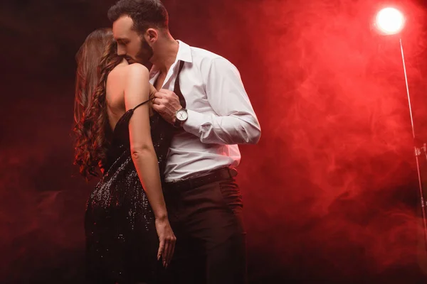 Apaixonado casal sedutor no quarto fumegante vermelho — Fotografia de Stock