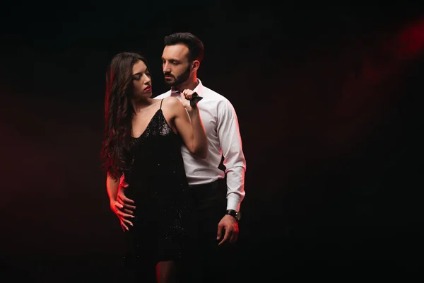 Attractive passionate couple hugging in dark room — Stock Photo