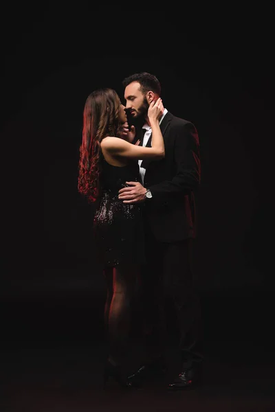 Sexy pareja abrazos y besos aislado en negro - foto de stock