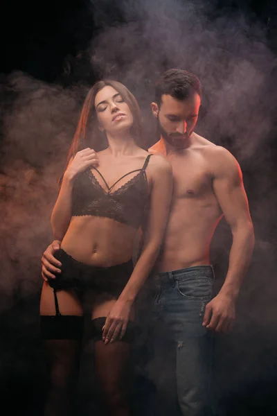 Couple amoureux passionné étreignant dans la chambre fumée — Photo de stock