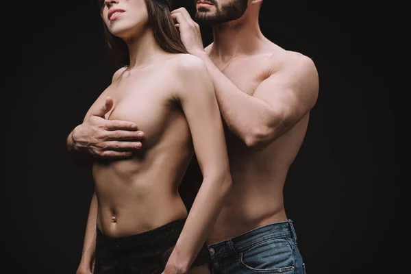 Cropped view of man hugging nude breast of beautiful girlfriend, isolated on black — Stock Photo