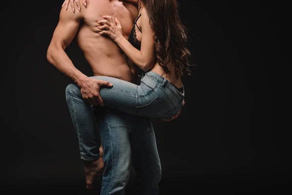 Recortado vista de apasionado hombre celebración y abrazo novia aislado en negro - foto de stock