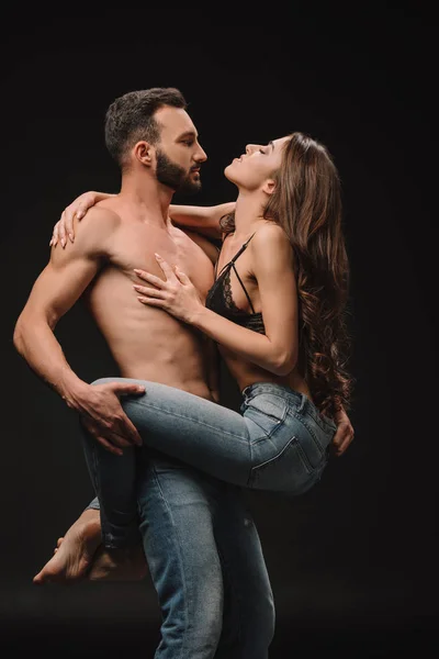 Sexual apaixonado casal abraçando juntos isolado no preto — Fotografia de Stock