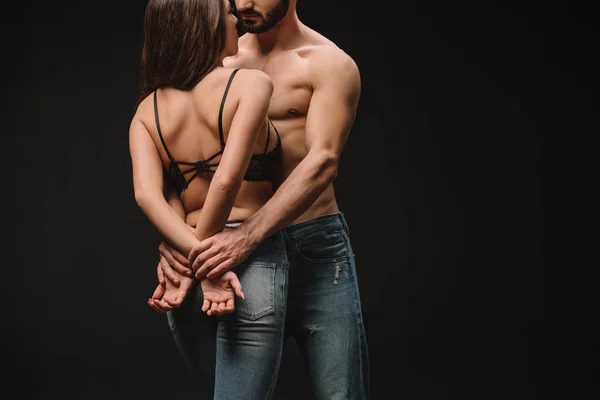 Cropped view of beautiful passionate couple hugging isolated on black — Stock Photo