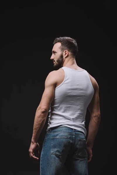 Rückansicht von sexy Mann posiert in weißem Singlet isoliert auf schwarz — Stockfoto