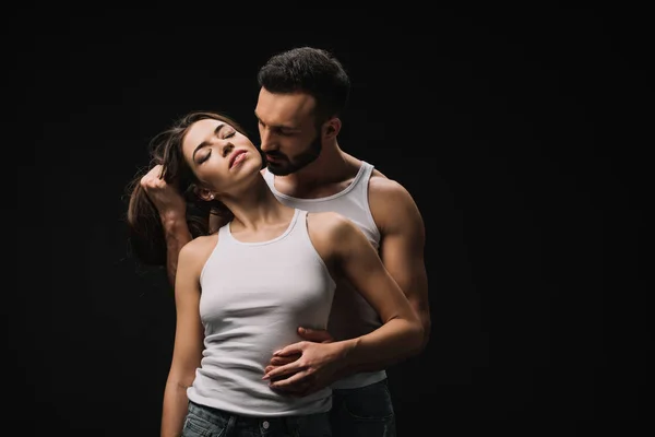 Bonito homem abraçando sedutor menina isolado no preto — Fotografia de Stock