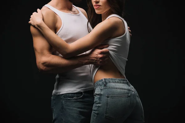Cropped view of man hugging and undressing girl isolated on black — Stock Photo