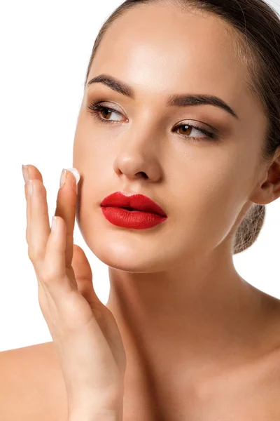 Belle fille avec des lèvres rouges appliquer crème sur le visage isolé sur blanc — Photo de stock