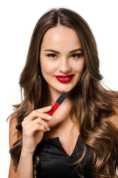 Beautiful girl smiling, looking at camera and holding red liquid lipstick isolated on white — Stock Photo