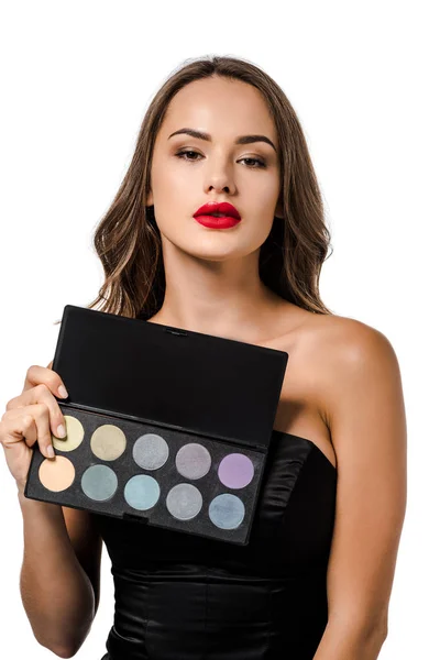 Attractive girl holding palette with eyeshadows and looking at camera isolated on white — Stock Photo
