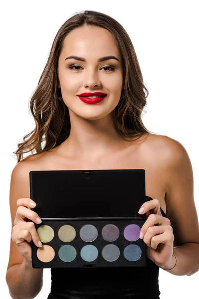Beautiful girl holding palette with eyeshadows, looking at camera and smiling isolated on white — Stock Photo