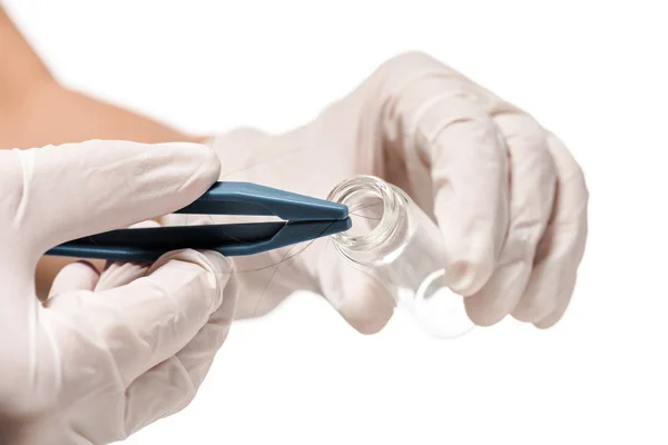 Cropped view of woman in disposable gloves putting hair in test tube isolated on white — Stock Photo