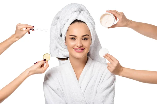 Cropped view of women holding cosmetic accessories and beautiful girl in bathrobe isolated on white — Stock Photo