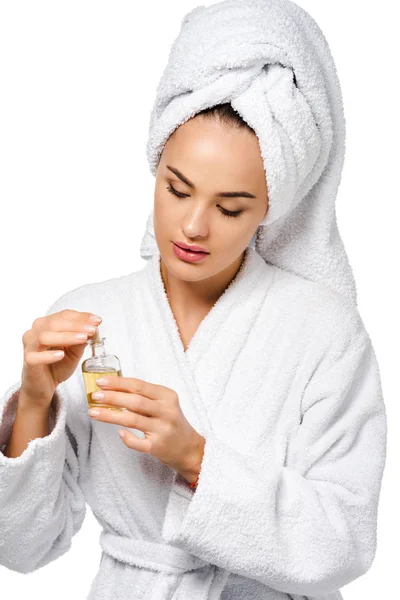 Jolie fille en peignoir tenant bouteille d'huile isolée sur blanc — Photo de stock