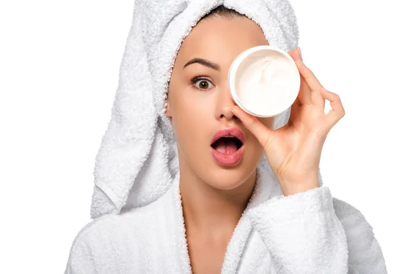 Beautiful girl in bathrobe making grimace and having fun with jar of cream isolated on white — Stock Photo