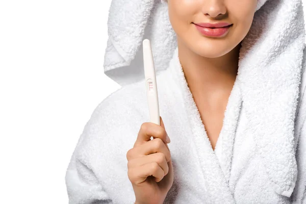 Cropped view of girl in bathrobe smiling and showing pregnancy test isolated on white — Stock Photo