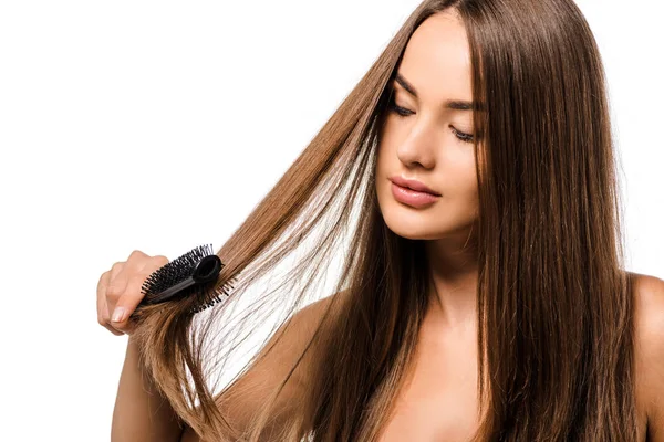 Hermosa chica peinando el cabello con cepillo aislado en blanco - foto de stock