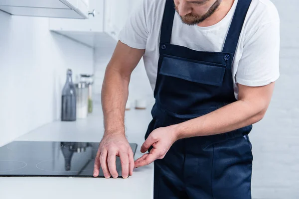 Tiro recortado de manitas en el trabajo en general horno de fijación en la cocina - foto de stock