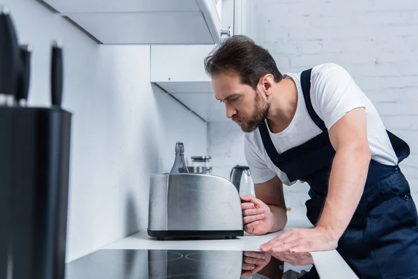 Sérieux bricoleur dans le travail global de fixation grille-pain dans la cuisine — Photo de stock