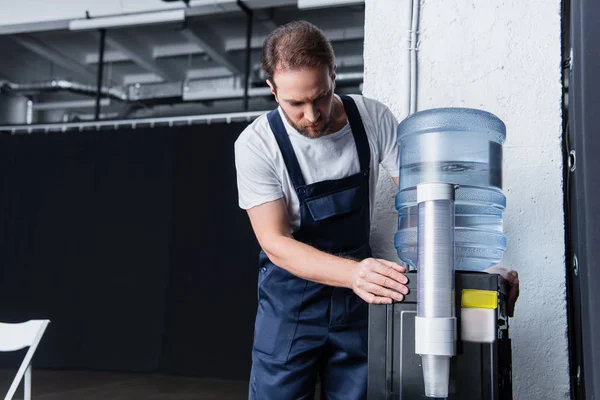 Seriöser Handwerker im Arbeitsalltag, der kaputte Wasserkühler überprüft — Stockfoto