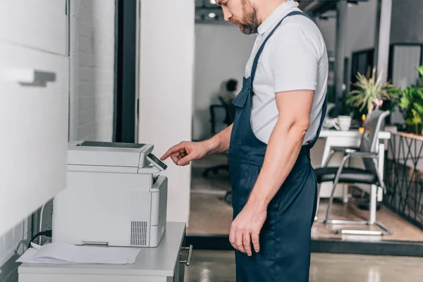 Cropped image of male handyman repairing copy machine in modern office — Stock Photo