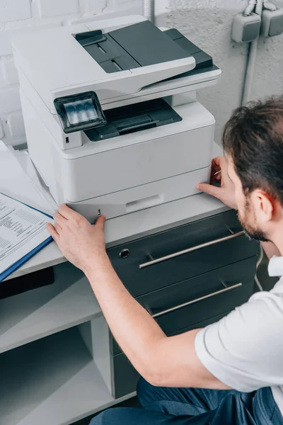 High angle view of male handyman repairing copy machine in modern office — Stock Photo