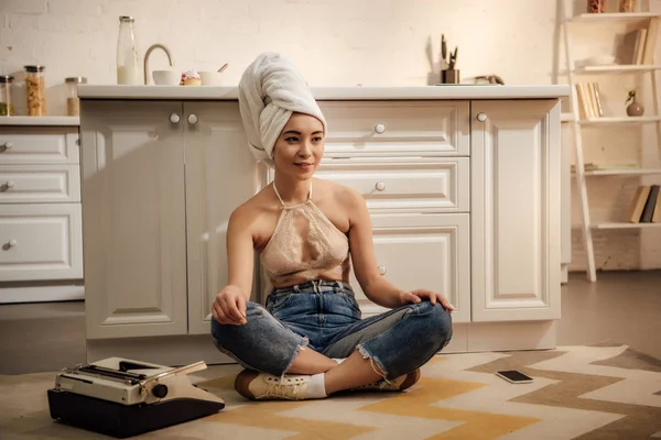 Sorridente giovane autrice seduta sul pavimento e distogliendo lo sguardo da casa — Foto stock