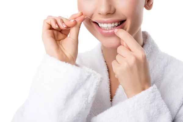 Vista recortada de la mujer en albornoz blanco dientes de hilo dental aislados en blanco - foto de stock