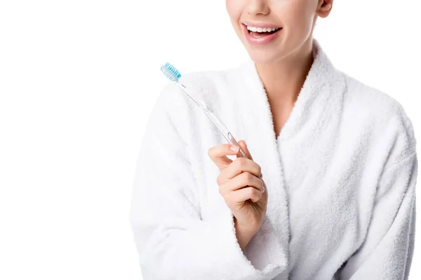 Vista parcial de la mujer en albornoz blanco sosteniendo cepillo de dientes aislado en blanco - foto de stock