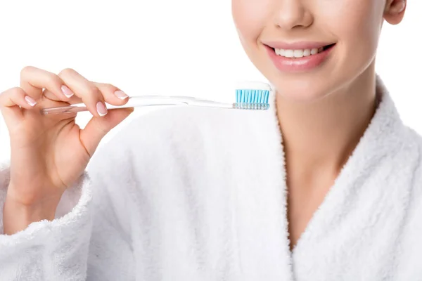 Cropped view of woman in white bathrobe holding toothbrush isolated on white — Stock Photo