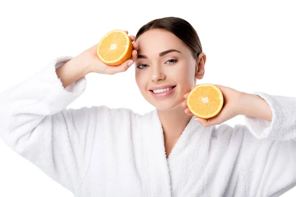 Красиві усміхається жінка в білий халат проведення апельсини і дивлячись на камеру, ізольовані на білому — стокове фото