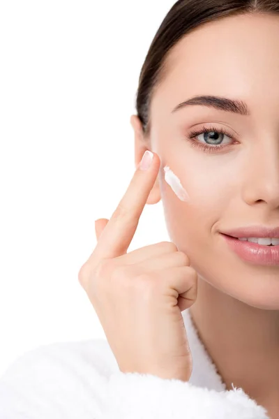 Close up of woman applying moisturizing face cream isolated on white — Stock Photo