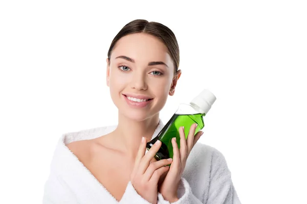 Belle femme souriante en peignoir tenant bain de bouche et regardant la caméra isolée sur blanc — Photo de stock