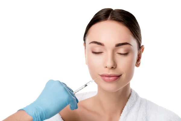 Doctor in latex glove giving lip injection with syringe to beautiful woman isolated on white — Stock Photo