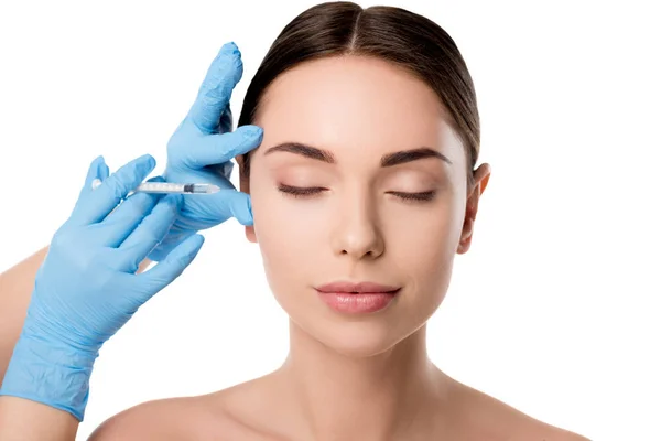 Doctor en guantes de látex dando inyección de belleza con jeringa a mujer con los ojos cerrados aislados en blanco — Stock Photo