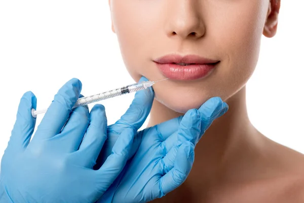 Abgeschnittene Ansicht des Arztes in Latex-Handschuhen, der Frau Lippeninjektion mit Spritze gibt, isoliert auf weißem Grund — Stockfoto