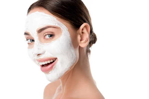 Bella donna sorridente con maschera per la cura della pelle del viso guardando la fotocamera isolata su bianco — Foto stock