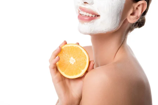 Cropped view of woman with facial skin care mask holding orange isolated on white — Stock Photo