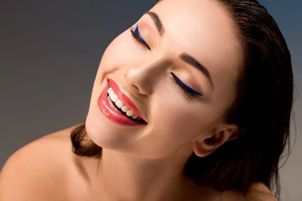 Retrato de hermosa mujer sonriente con maquillaje glamoroso y los ojos cerrados - foto de stock