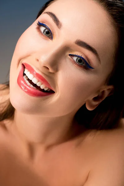 Портрет красивой улыбающейся женщины с гламурным макияжем, смотрящей в камеру — стоковое фото