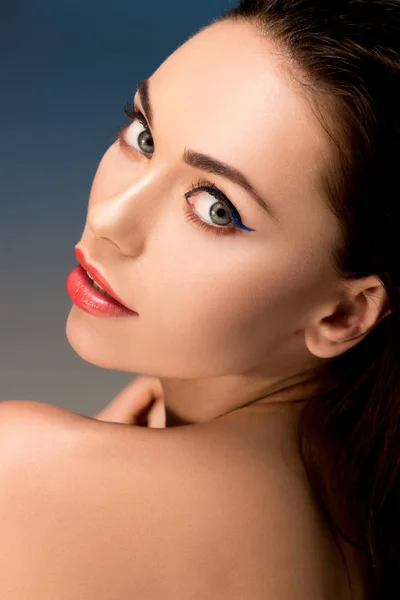 Retrato de mujer atractiva con maquillaje glamoroso mirando a la cámara - foto de stock