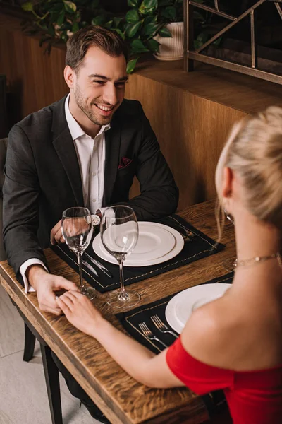 Bonito namorado segurando mão de namorada no vestido vermelho — Fotografia de Stock