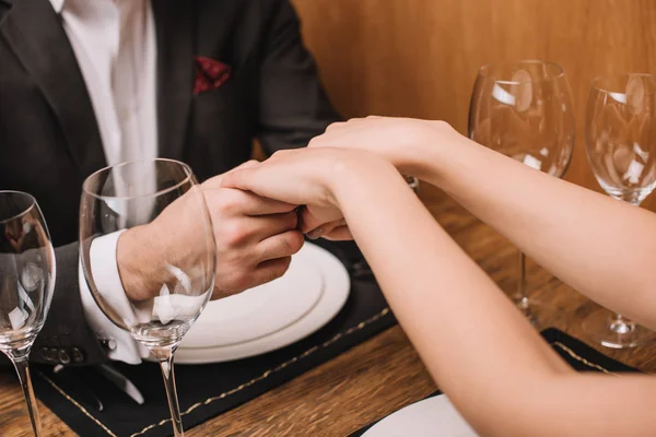 Парень и девушка держатся за руки в ресторане — стоковое фото
