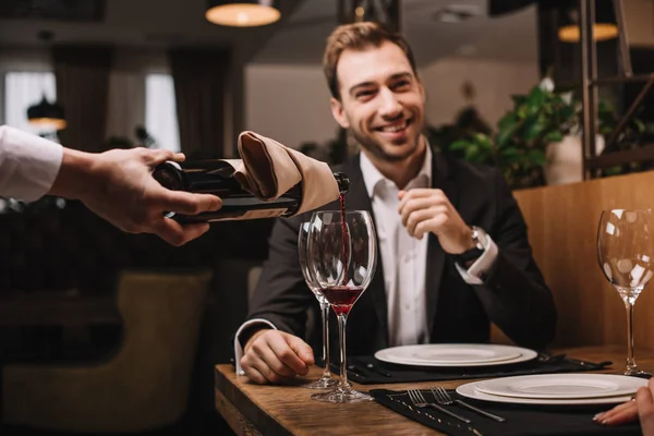 Foyer sélectif de l'homme attrayant en costume souriant et assis dans le restaurant — Photo de stock